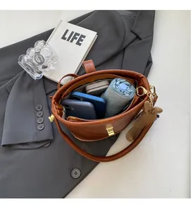 Intérieur spacieux du sac seau en cuir marron avec rangement pour téléphone et parapluie