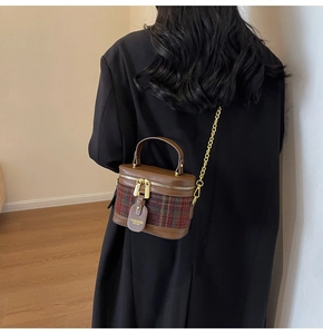 Close-up of retro plaid cylinder bucket bag with chain strap and leather handle