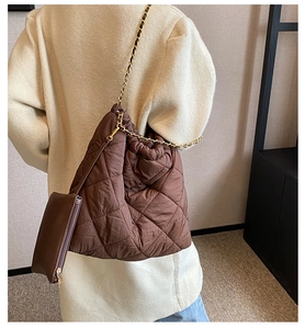 Détail macro du sac matelassé marron avec chaîne dorée et pochette détachable