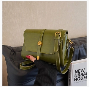 Détail d'un sac bandoulière en similicuir vert olive avec boucle anneau dorée