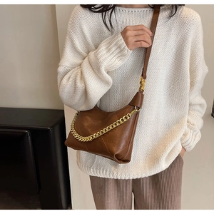 Detail of vintage brown quilted shoulder bag with chunky gold chain and leather strap