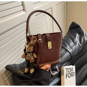 Détails du sac seau vintage marron avec boucle dorée et pendentif lapin mignon