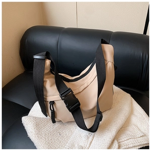 Detail of beige crescent nylon bag showing durable fabric and adjustable black strap