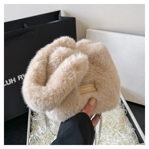 Detail of soft beige faux fur bucket bag with leather tag and elegant silver chain strap