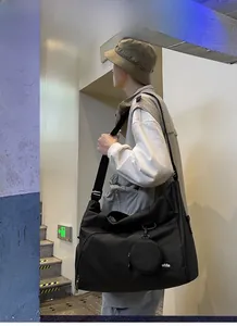 Detail der schwarzen Nylon-Reisetasche mit rundem Mini-Beutel und weißem Textband