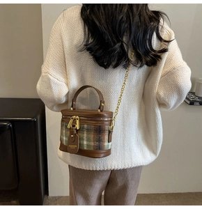 Detail of vintage plaid bucket bag with gold chain strap and dual zipper closure