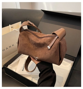 Dettaglio della texture in pelle satinata marrone e testo stampato sulla borsa