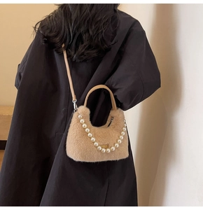 Dettaglio borsa in peluche con catena di perle e tracolla rimovibile per l'autunno-inverno
