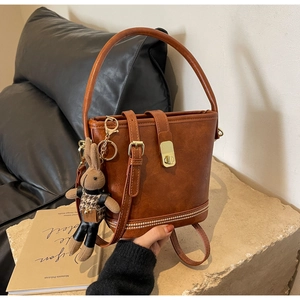 Détail du sac seau vintage marron avec boucle en métal et pendentif lapin mignon