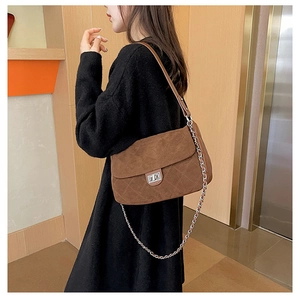 Detail of brown quilted matte suede shoulder bag with metal twist lock and chain strap
