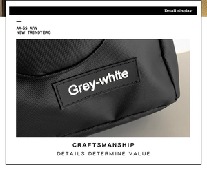 Detail der Waben-Nylonstruktur und des Grey-white Markenaufnähers auf der schwarzen Tasche