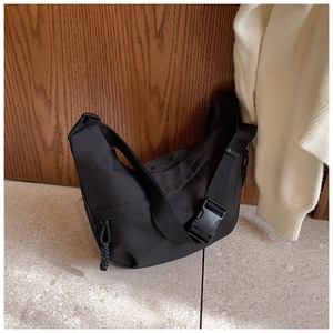 Detail of black nylon crescent bag with adjustable strap and plastic buckle closure