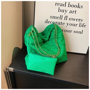 Détail du sac seau matelassé vert en nylon avec chaîne dorée et petite pochette