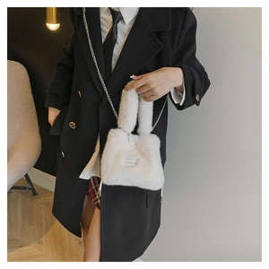 Close-up of fluffy faux fur bucket bag with metal chain and Love every day tag