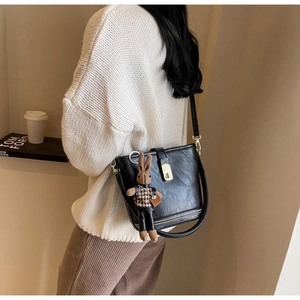 Détail du sac seau noir avec fermoir doré et accessoire de poupée lapin mignon