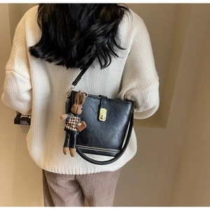 Détail du sac seau noir vintage avec fermoir doré et breloque lapin à carreaux chic