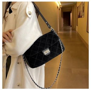Close-up of quilted black suede chain bag with vintage silver twist lock detail