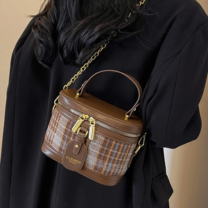 Retro tweed vanity bag with brown leather trim and golden chain strap on model