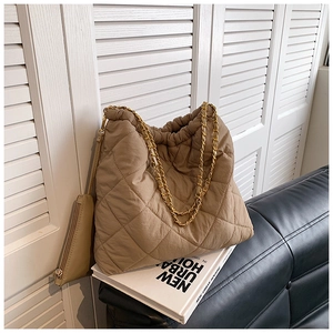 Détail macro du sac seau matelassé kaki avec bandoulière chaîne et petite pochette