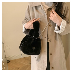 Detail of black faux fur bucket bag with silver chain strap and drawstring closure