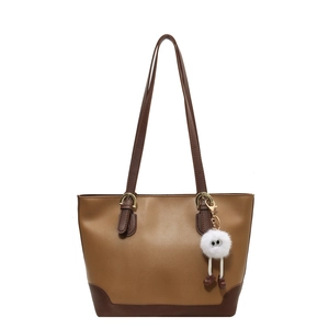 Large brown two-tone faux leather tote bag with a cute white plush monster charm