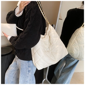 Sac cabas matelassé blanc avec bandoulière chaîne dorée vu dans le miroir