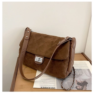 Detail of coffee brown quilted suede bag with silver square twist lock and chain strap