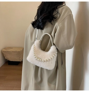 Dettaglio della borsa morbida bianco panna con catena di perle e texture in ecopelliccia