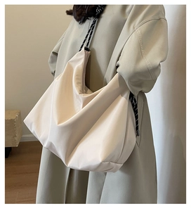 Close-up of cream nylon tote bag with black and white braided rope handle strap