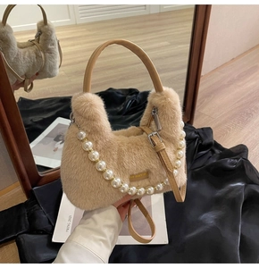 Dettaglio della borsa in peluche kaki con catena di perle e manico in pelle