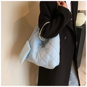 Détail d'un sac Oxford matelassé bleu clair avec mini pochette et bandoulière en chaîne