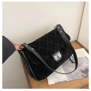 Close-up of black quilted shoulder bag with matte texture and silver turn-lock closure