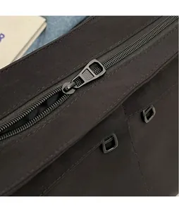 Détail macro de la fermeture éclair métallique lisse sur un sac cabas noir en toile