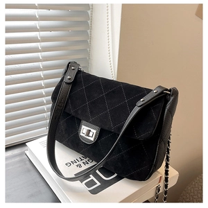Detail of silver twist lock and quilted matte texture on the black shoulder bag