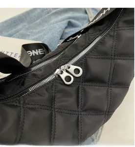 Dettaglio delle doppie cerniere argentate e della trama in nylon trapuntato della borsa