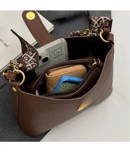 Interior view of brown pebble leather bag showing storage space for phone and wallet