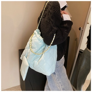 Détails du sac seau en nylon matelassé bleu clair avec chaîne dorée et mini pochette