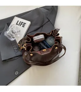 Deep brown leather bucket bag showing large interior capacity for daily essentials