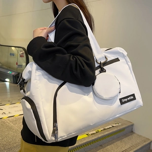 Große weiße Reisetasche mit schwarzen Reißverschlüssen und kleinem rundem Anhänger