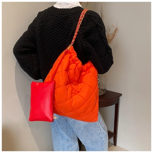 Détail du cabas matelassé orange vif avec chaîne dorée et pochette zippée rouge