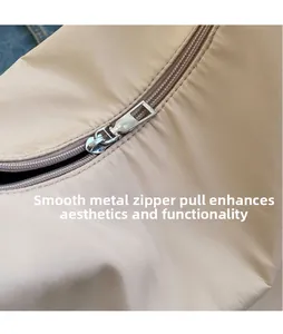 Detailed macro view of the silver glossy metal zipper slider on a beige nylon tote bag