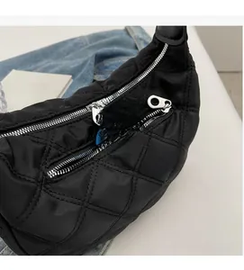 Vista dettagliata della borsa in nylon nero trapuntato con tasca anteriore a zip