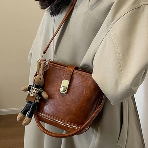 Sac seau rétro en cuir caramel avec serrure dorée et breloque lapin en peluche doux