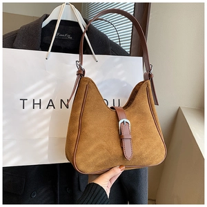 Dettaglio della borsa hobo in pelle scamosciata marrone con fibbia in metallo vintage