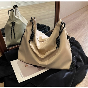Detailed shot of beige Oxford tote bag showing weave strap detail and smooth nylon fabric
