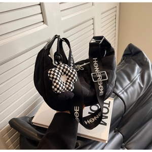 Dettaglio borsa hobo nera trapuntata con tracolla HONERSOE e ciondolo a fiore