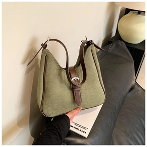 Dettaglio della borsa sottobraccio in pelle scamosciata verde oliva con finiture marroni