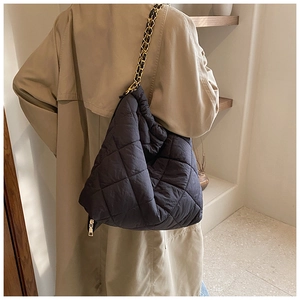 Détail du sac seau noir matelassé en tissu oxford avec bandoulière chaîne dorée