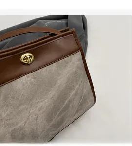 Detail of vintage two-tone tote bag featuring grey textured fabric and brown leather handle