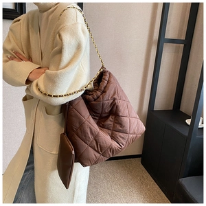 Détail du sac hobo marron matelassé avec chaîne dorée et porte-monnaie assorti attaché